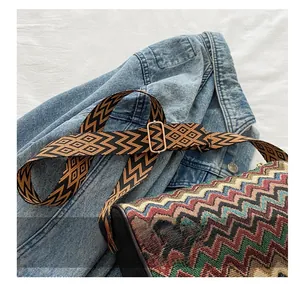 Close-up of ethnic style woven strap with geometric patterns and golden metal buckle
