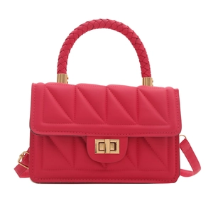 Rose pink quilted square bag with woven handle and gold twist lock closure on white background
