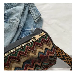 Detail view of ethnic jacquard fabric texture and smooth gold metal zipper on crossbody bag
