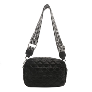 Black quilted puffer crossbody bag with a wide striped shoulder strap on white background