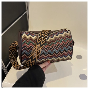 Close-up of bohemian zigzag woven texture and golden hardware on the cylinder crossbody bag