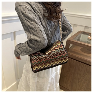Close-up of ethnic style zigzag woven crossbody bag with colorful stripes and wide strap