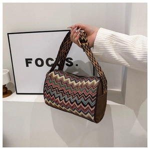 Detail of colorful zigzag woven fabric and wide ethnic shoulder strap on cylinder bag