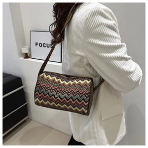 Close-up of colorful wavy knit pattern and leather trim on ethnic crossbody bag