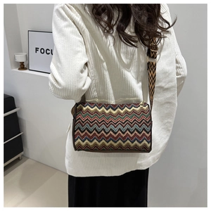 Detailed back view of cylindrical crossbody bag with colorful zigzag woven patterns