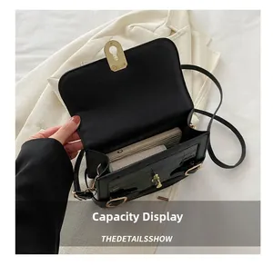 Detailansicht der Innenkapazität der schwarzen Tasche mit Krokoprägung und Goldbeschlag