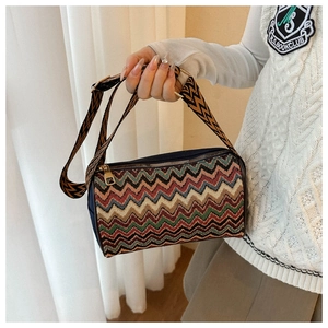 Detail of bohemian knit cylinder bag featuring colorful zigzag patterns and gold zipper