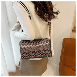 Detailed shot of ethnic striped knit crossbody bag with wide woven strap and zipper