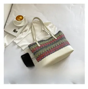 Size comparison showing the wave pattern woven tote bag next to a smartphone
