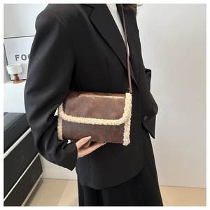 Detail of faux shearling trim on dark brown vintage leather crossbody hobo bag
