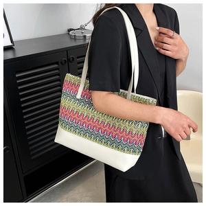 Detail of colorful zigzag woven tote bag with white faux leather base and handles