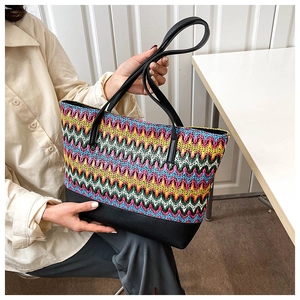 Bohemian style woven tote bag with colorful wave patterns and black leather base