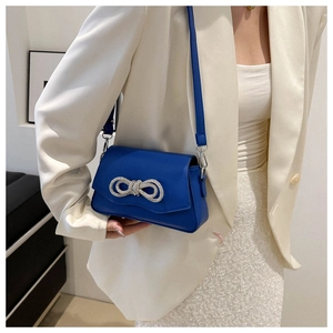 Détail du sac bandoulière bleu roi avec nœud en strass étincelant et boucle argentée chic
