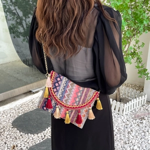 Bohemian woven crossbody bag with colorful geometric patterns and decorative tassels