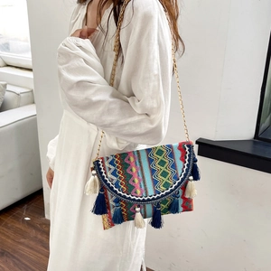 Bohemian woven chain bag with colorful embroidery and tassels shown on model