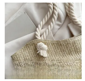 Detail of woven straw tote bag featuring thick cotton rope handles and fine textures