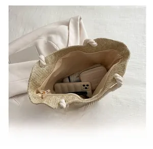 Interior view of straw tote bag showing spacious capacity for phone, wallet, and umbrella