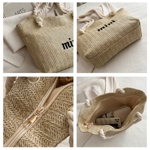 Detail view of beige woven tote bag showing rope handles, zipper closure and inner space