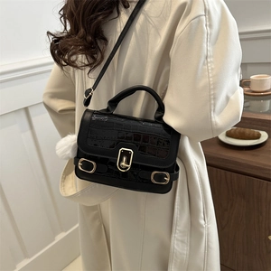Fashionable black faux crocodile skin crossbody bag with gold lock and plush charm