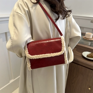 Red crossbody bag with sheepskin trim over a beige coat for an autumn fashion look