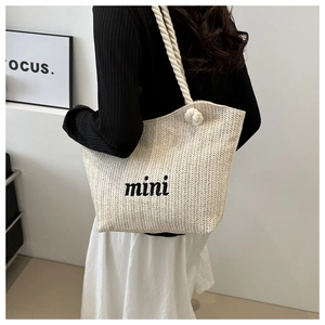 Detailed close-up of woven tote bag with mini embroidery and thick cotton rope handles