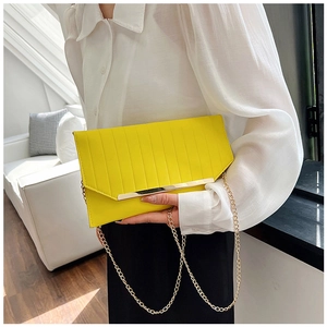 Detail der gelben Umschlagtasche mit Goldbesatz und Ketten-Schulterriemen für Damen