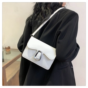 Detailed back view of a white minimalist square crossbody bag on a black blazer