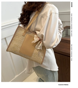 Detail of straw woven tote bag featuring white lace bow and elegant leather handles