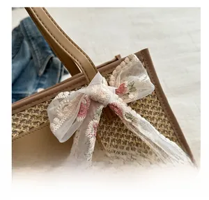 Detail of woven tote bag featuring a floral lace bow and premium leather patch