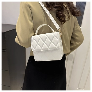 Vue arrière du petit sac à main blanc matelassé porté à l'épaule sur un blazer olive