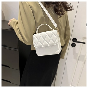 Vue détaillée d'un sac à bandoulière matelassé blanc porté par un mannequin