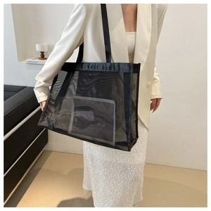 Detail of black mesh tote bag with nylon straps on female model for casual work look