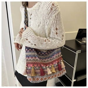 Detail of bohemian tote bag with colorful jacquard patterns and vibrant fringe tassels