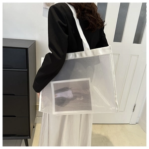 Detail of white mesh tote bag showing breathable material and large storage capacity