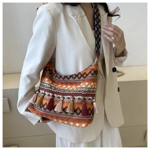 Detail of bohemian woven shoulder bag with ethnic patterns and colorful tassels