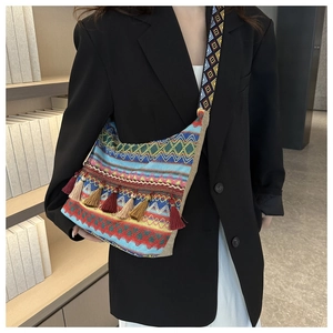 Detail of bohemian jacquard tote bag featuring colorful tassels and ethnic shoulder strap