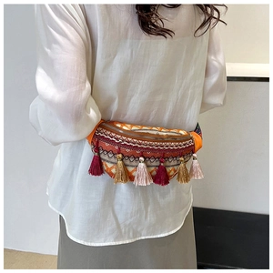 Ethno-Gürteltasche mit geometrischer Stickerei und bunten Quasten auf weißem Outfit