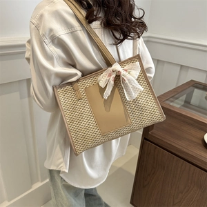 Large straw woven tote bag with brown leather straps and floral lace ribbon detail