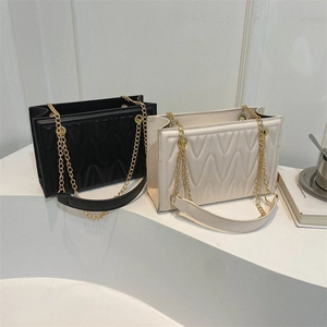 Chic quilted underarm chain bags in black and beige displayed on a white stand