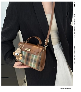 Detail of vintage plaid handbag with brown leather trim and golden twist lock