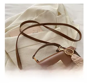 Detail of vintage brown leather bag with golden twist lock on white linen blazer