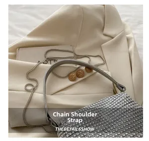 Detailed view of silver rhinestone handbag with elegant metal chain and leather strap