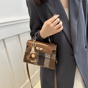 Retro brown checkered wool and leather handbag with metallic clasp on model