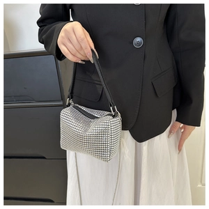 Detail of silver rhinestone handbag showing crystal surface and metal chain strap