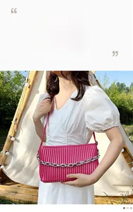 Detail of rose pink pleated leather bag with silver metal chain and shoulder strap