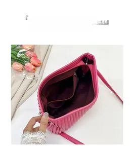 Interior detail of fuchsia pleated crossbody bag showing zip pocket and lining