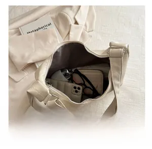 Spacious interior of beige PU leather shoulder bag holding a phone and wallet