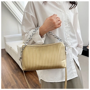 Detailed close-up of a gold pleated shoulder bag with chic silver chain strap and leather belt