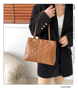 Detailed view of brown quilted PU leather tote bag with gold metal chain strap