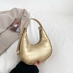 Minimalist pale gold crescent moon handbag with embossed crocodile texture and metal buckle